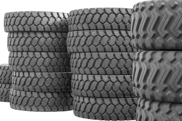 Large rubber tires for trucks lying on the street. Many close-up tires with a large tread are lying on the ground.