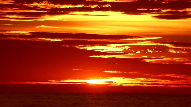 red flame sunset on orange sky and red cloud on the sea