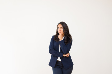 Woman with hand on chin looking away. Thoughtful young businesswoman looking aside isolated on grey...