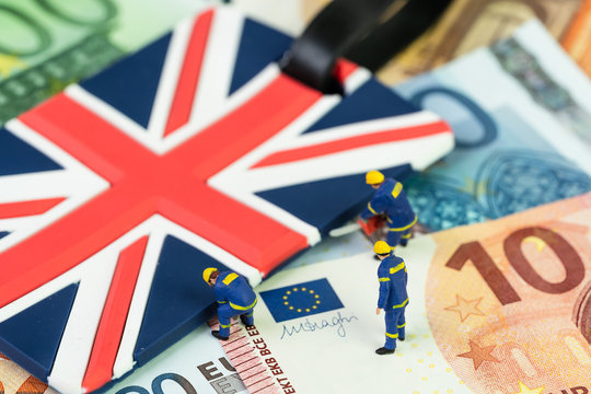 Brexit negotiation plan or Euro zone withdrawal concept, miniature figures worker help move UK Union jack flag from pile of Euro banknotes money