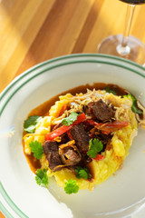 Close up of a traditional russian beef stroganoff with gravy, mashed potatoes and caramelized onion served on a summer terrace