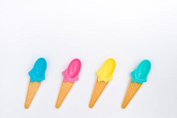 Summer bright ice cream spoons on white background