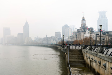 Historical architecture on the bund of Shanghai with reflection of buildings on rain and mist in city, the Bund is a popular tourist destination of Shanghai, China