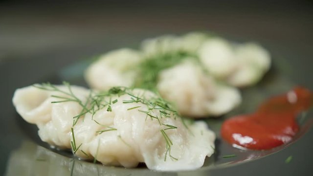 Cook pours the sauce on the boild dumplings
