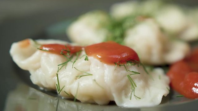 Cook pours the sauce on the boild dumplings