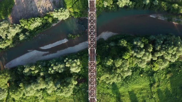 Metal railroad bridge above a river. Aerial drone view. UHD 4K video