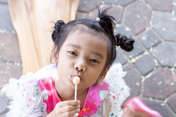 Girl eat lollipop happily on holiday at the park.