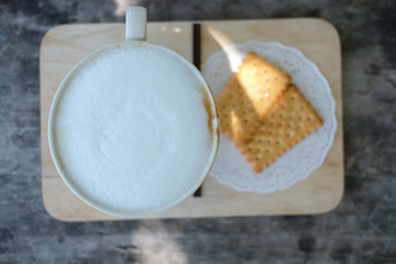 hot coffee latte & cracker on wood table.