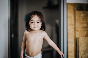Asian toddler (eighteen months) with diaper in the room. - obrazy, fototapety, plakaty