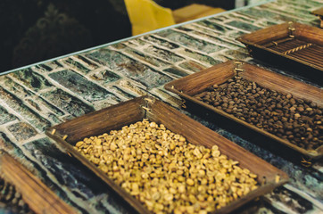 unroasted and roasted coffee beans in trays