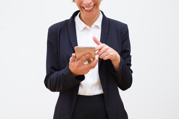 Cropped shot of woman using smartphone. Cheerful businesswoman in formal wear using mobile phone...