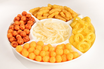 Mix of snacks on a white plate isolated on white.