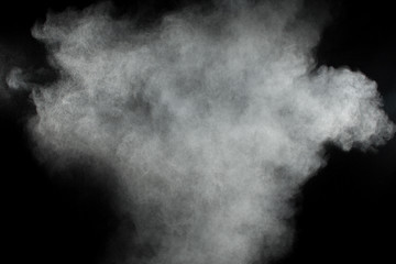 White powder explosion clouds.Freeze motion of white dust particles on black background.