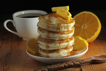 A stack of freshly backed pancakes and a cup of coffee