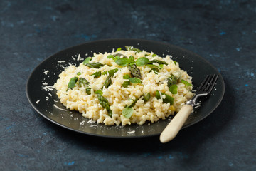 Classic Italian risotto with asparagus. Front view. Darkblue background.