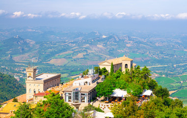 Aerial top panoramic view of Basilica, Palazzo Pubblico palace and landscape with valley, green...