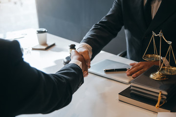 Businessman shaking hands to seal a deal with his partner lawyers or attorneys discussing a...