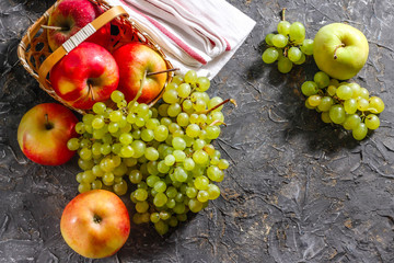 Harvest of apples and grapes on a stone background. Autumn harvest.