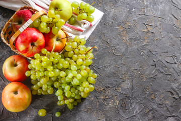 Harvest of apples and grapes on a stone background. Autumn harvest.