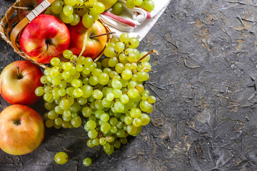Harvest of apples and grapes on a stone background. Autumn harvest.