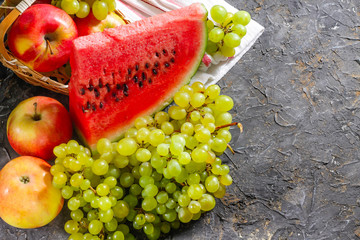 Watermelon, grapes and apples on a stone background. Autumn harvest.