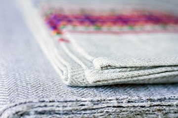 A stack of woven linen towels with embroidery, traditional handmade in Ukraine.