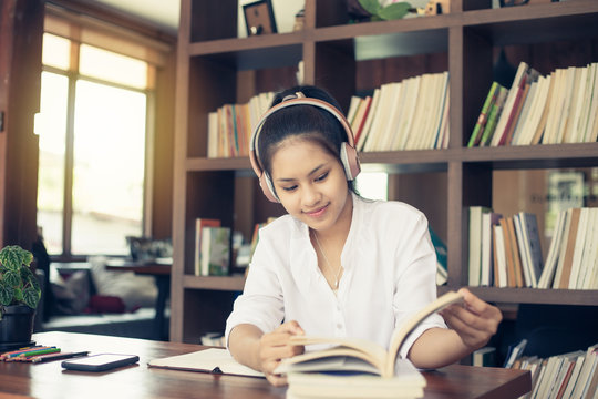Asian female student sitting reading in the library.