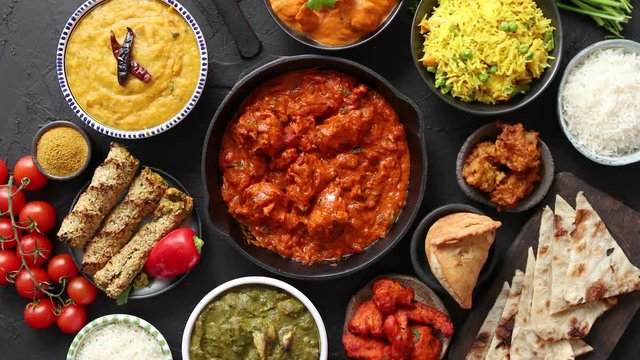 Assortment of various kinds of Indian cousine on dark rusty table