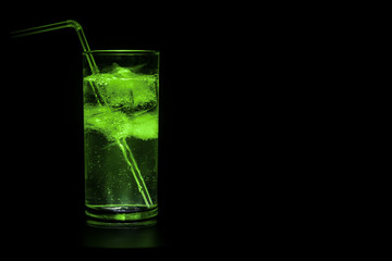 Cocktail glass splashing on dark toned smoky background or colorful cocktail in glass. Party club entertainment. Mixed light.