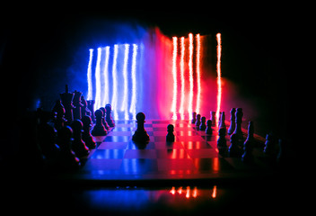 Chess board game concept of business ideas and competition. Chess figures on a dark background with smoke and fog.