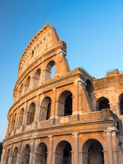 Vertical view to wall with arch of colosseum with blue sky in Rome in Italy - obrazy, fototapety, plakaty