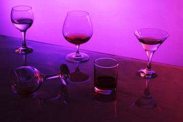 glasses with cocktails on color background