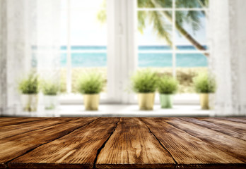 Table background with wooden top board. Empty space for a product. Beautiful ocean view outside the window.