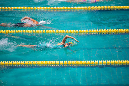 Athlete in freestyle swimming race in swimming pool