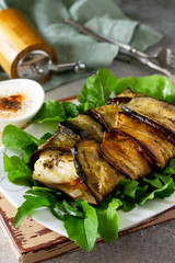 Delicious fish baked with vegetables in an eggplant grilled on a stone or slate table.