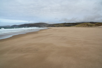 Fototapeta na wymiar Sandwood Bay is a natural bay in Sutherland, on the far north-west coast of mainland Scotland. It is best known for its remote 1 mile long beach and Am Buachaille, a sea stack, and lies about 5 miles 