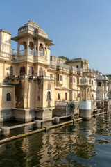 Fototapeta na wymiar Architecture, decorated facade near water lake in Udaipur, Rajasthan, India