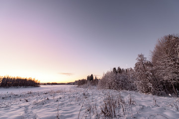 The ice lake and forest has covered with heavy snow and nice blue sky in winter season at Holiday Village Kuukiuru, Finland.