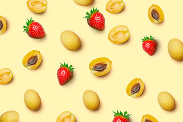 Apricots and strawberrys on a colored background. Pattern of a apricots and strawberrys. Fresh fruit composition on a colored background,flat lay, top view