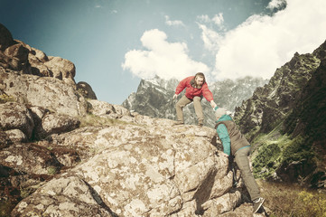 Two mans help each other hiking