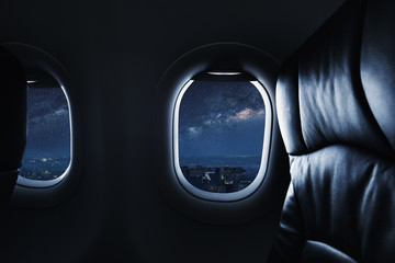Looking through airplane window at night with sky full of stars and milky way © SasinParaksa