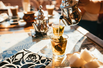 Pouring a cup of spicy tea with herbs
