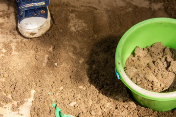 Children play in a sandbox with molds and knives. Sculpting sand figures.