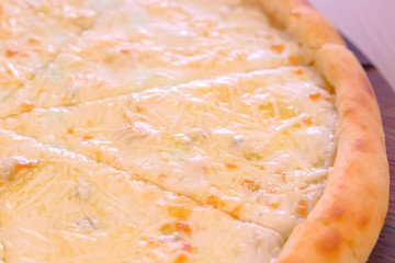 Half of slicing pizza with different types of cheese close-up view
