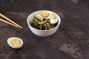 Far Eastern salad - sea kale with egg in a white cup.