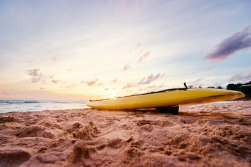 Beautiful landscape. Sunset on the sea beach with lifeguard surf board on sand.