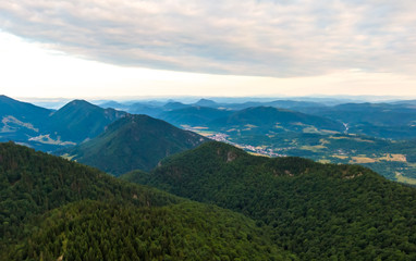 Aerial view to Mala Fatra mountains in Slovakia. Sunrise above mountain peaks and hills in far. Beautiful nature, vibrant colors. Famous tourist destination for hiking and trekking. Cloudy weather.