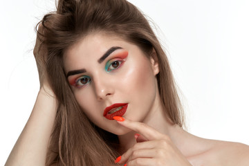 Closeup portrait of beautiful young woman with bright color make-up holding hands with bright  manicure close to face