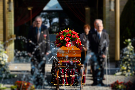 Blurred image of family standing by a coffin at a funeral