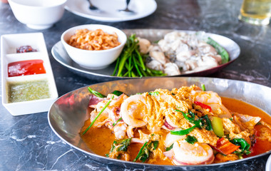 Close up view of Stir Fried Squid with Curry. And seafood on table of restaurant in Thailand.